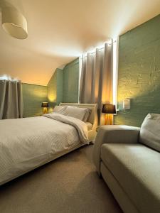 a bedroom with a large bed and a couch at Flat in the centre of Deal Town in Deal