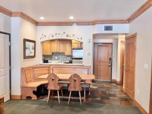 a kitchen with a wooden table and two chairs at Cozy Family Zermatt King Villa with Kitchen Near Park City & Deer Valley Ski Resorts - 1085 in Mound City