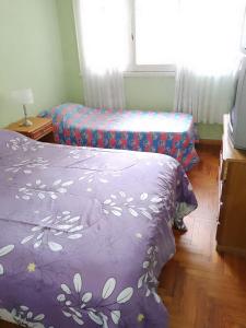 a room with two beds and a tv and a window at 6 personas playa grande con reservación previa in Mar del Plata