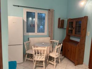 eine Küche mit Tisch und Stühlen und einem Kühlschrank in der Unterkunft Elena's Guest House in Aiándion