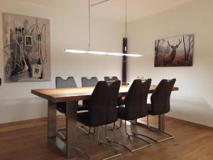 a dining room with a wooden table and black chairs at Chäserruggblick in Unterwasser
