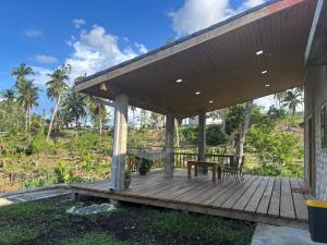 eine Holzterrasse mit einem Tisch und Stühlen darauf in der Unterkunft The Ridge - Stone Cottage in Buff Bay