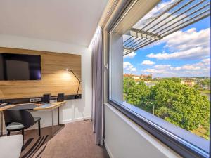 pokój z dużym oknem z biurkiem i widokiem w obiekcie Novotel Kraków Centrum w Krakowie +252 zdjęcia