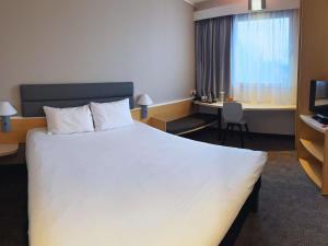 een hotelkamer met een groot bed en een bureau bij Ibis Katowice - Zabrze in Zabrze