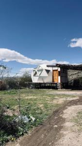een huis dat bovenop een veld staat bij Domos Andinos HostCamp in Potrerillos