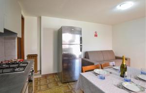 蓬圣马丁2 Bedroom Stunning Home In Pont-Saint-Martin的厨房配有冰箱和带盘子的桌子