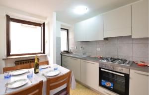 蓬圣马丁2 Bedroom Stunning Home In Pont-Saint-Martin的一间厨房,配有白色家电和一张桌子及两把椅子