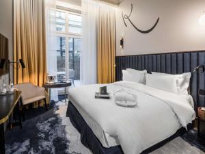 a hotel room with a large bed and a desk at Century Old Town Prague - MGallery Collection in Prague