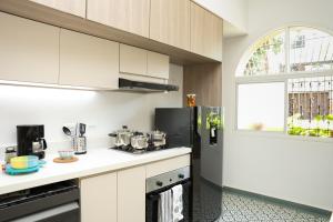 una cucina con mobili bianchi e un frigorifero nero di Casa del Viento 102 a Cali Altre 5 foto