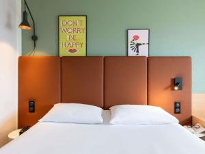 Un dormitorio con una cama grande con sábanas blancas. en Hotel ibis Rennes Centre Gare Sud, en Rennes 131 fotos más