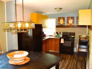 een keuken met een zwarte koelkast en een tafel bij 7-Bedroom Retreat Sleeps 13 in East Grand Forks
