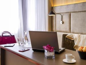 a desk with a laptop computer on top of it at Mercure Sao Paulo Jardins in Sao Paulo