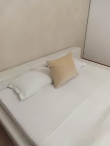 ein weißes Bett mit zwei weißen Kissen darauf in der Unterkunft Maison 29 in Braşov