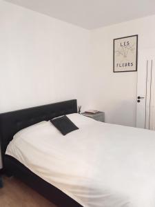 ein weißes Bett mit einem schwarzen Kopfteil in einem Schlafzimmer in der Unterkunft Maison 29 in Braşov + 5 Fotos