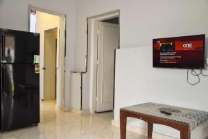 a living room with a black refrigerator and a table at El Hady Guesthouse in Luxor