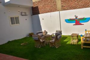 a group of people sitting at a table in a yard at El Hady Guesthouse in Luxor