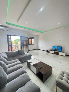 a large living room with couches and a tv at Immeuble Sali Laye in Darou Rhamane
