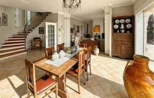 une salle à manger avec une table et des chaises et un escalier dans l'établissement Pet Friendly Home In Vallecrosia, à San Biagio della Cima