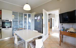 une cuisine et une salle à manger avec une table et des chaises blanches dans l'établissement Pet Friendly Home In Vallecrosia, à San Biagio della Cima