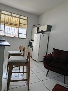 a kitchen with a refrigerator and two chairs and a couch at Apartamento inteiro Iguaçu Ipatinga in Ipatinga +3 photos