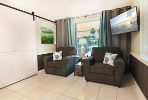 a living room with two chairs and a flat screen tv at Salty Shores Secluded Oasis in Englewood
