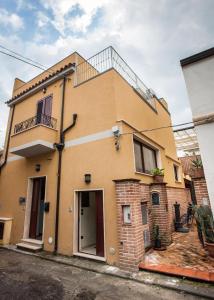 una casa amarilla con una escalera en la parte superior en Eutimo, en Locri