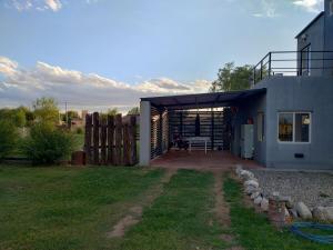 ein Haus mit einer Garage und einem Zaun in der Unterkunft EL REFUGIO DE MERLO, alquiler temporario in Merlo