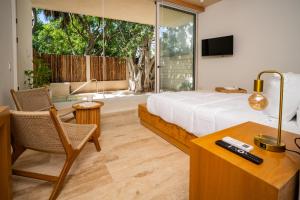 une chambre avec un lit, un bureau et une télévision dans l'établissement Greta Puerto Morelos, à Puerto Morelos