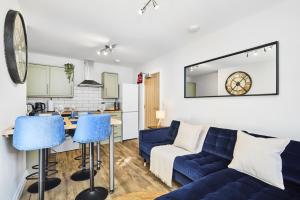 ein Wohnzimmer mit einer blauen Couch und einer Küche in der Unterkunft Estcourt Avenue Apartments in Headingley + 11 Fotos