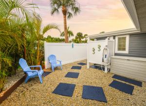 a patio with two blue chairs and a house at Salty Shores Secluded Oasis in Englewood