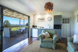 ein Wohnzimmer mit einem Stuhl und eine Küche in der Unterkunft Grasmere Farm in Gruyere