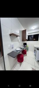 a kitchen with a black counter and red stools at Apartamento Caruaru bem localizado in Caruaru +3 photos