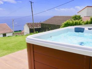 a large bath tub sitting on top of a yard at Casabelavista Iii in Fajã do Araújo