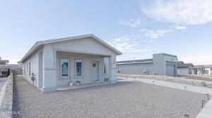 a small white building on a gravel road at Confortable House in West Side in Canutillo