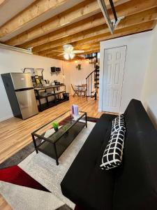 a living room with a black couch and a table at NYC-Style Loft with Secret Entrance - Just 6 Miles from Times Square in North Bergen