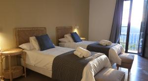 a hotel room with two beds with towels on them at Hotel Rural Mirador de Jubrique in Jubrique