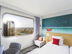 a hotel room with a bed and a window at Novotel Paris Centre Tour Eiffel in Paris