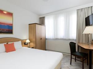 a hotel room with a bed and a desk at Résidence Studio Genève Centre in Geneva