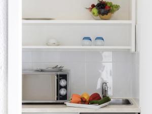 a kitchen with a microwave and a plate of fruit at Résidence Studio Genève Centre in Geneva