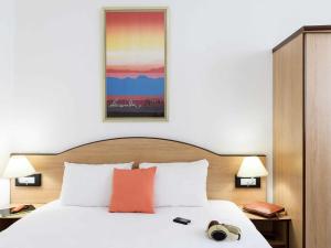 a bed in a hotel room with a picture on the wall at Résidence Studio Genève Centre in Geneva +13 photos