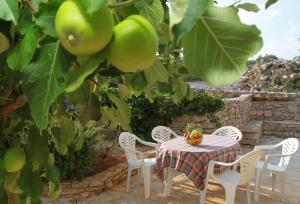 a table and chairs under a tree with apples at Geräumige Ferienvilla Mit Pool Und Meerblick in Grohote +25 photos