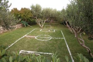 a soccer field in a yard with trees at Geräumige Ferienvilla Mit Pool Und Meerblick in Grohote