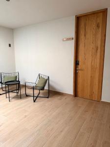 Dos sillas en una habitación vacía con una puerta de madera en Bauer Haus, en Laborcillas