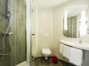 a bathroom with a shower and a toilet and a sink at Ibis Granada in Granada +104 photos