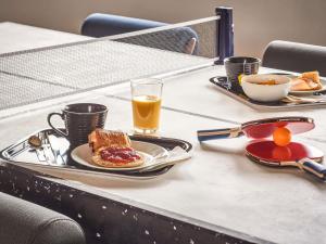 a table with a breakfast of toast and coffee and orange juice at Ibis Budget Bilbao Arrigorriaga in Arrigorriaga