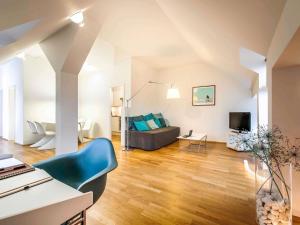 a living room with a couch and a tv at Mercure Hotel München Altstadt in Munich