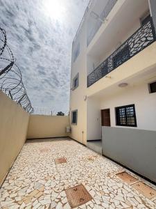 an empty courtyard of a building with the sky in the background at Immeuble Sali Laye in Darou Rhamane