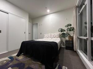 Un dormitorio con una cama y una planta en maceta. en Adjacent to the Sky Tower, with a super large space, en Auckland 35 fotos más