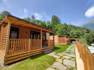 a log cabin with a porch and a patio at Camping Val di Sole in Peio