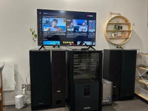 Un televisor de pantalla plana encima de un sistema de videojuegos en Adjacent to the Sky Tower, with a super large space, en Auckland